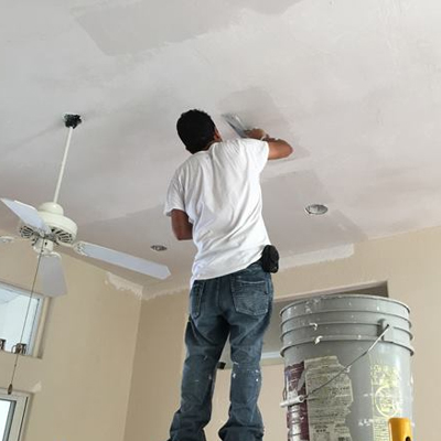 A drywall professional patching the ceiling