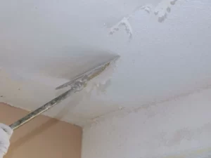 A professional removing a popcorn ceiling